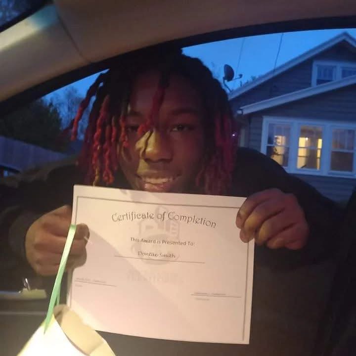 Dontae Smith proudly holding his Certificate of Completion