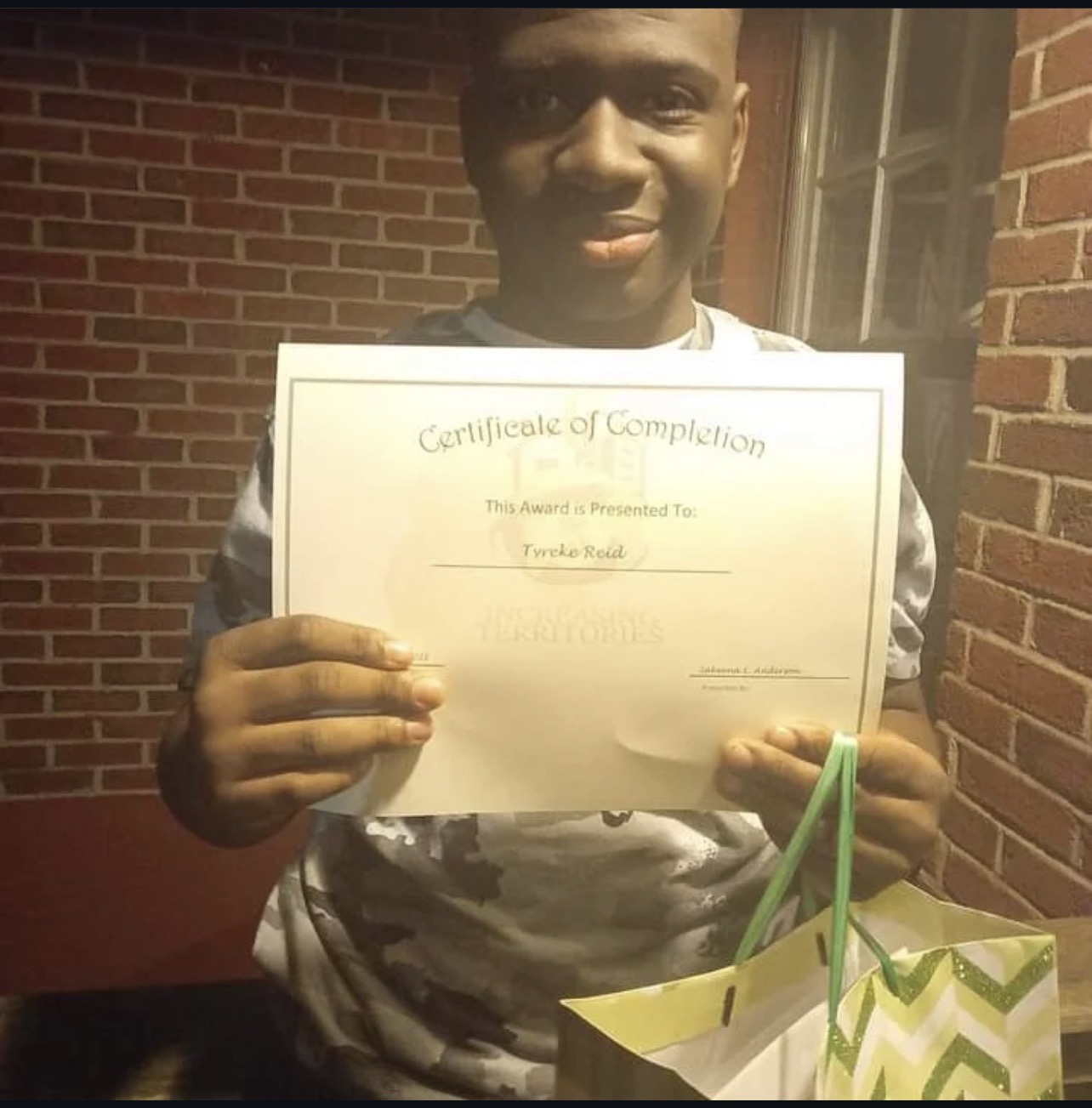 Tyreke Reid holding his Increasing Territories Certificate of Completion